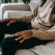 A man sitting on a couch with his hands resting on his lap.